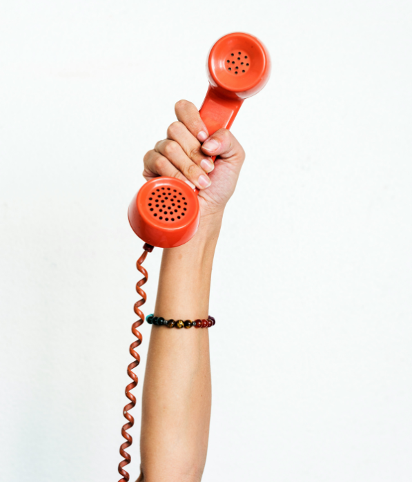 Woman's arm holding up an old-fashioned telephone receiver